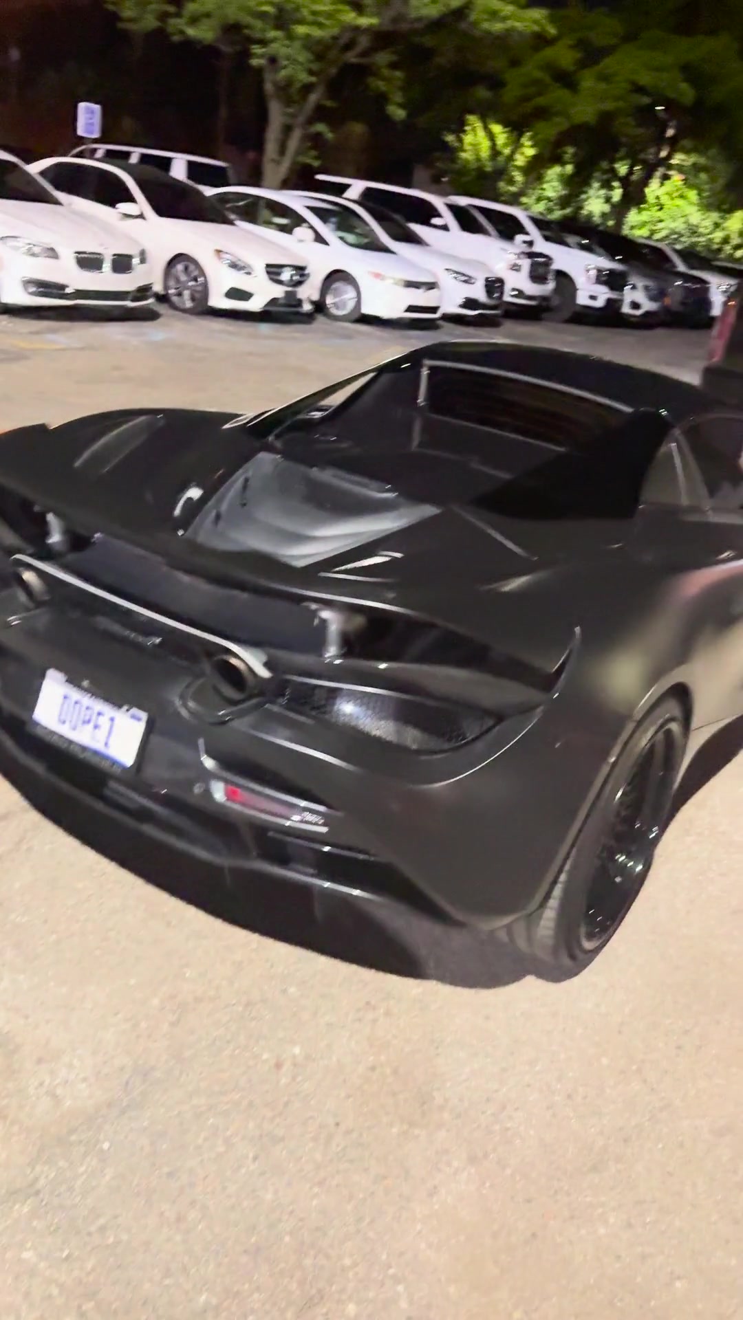 A dark sports car in an event parking area