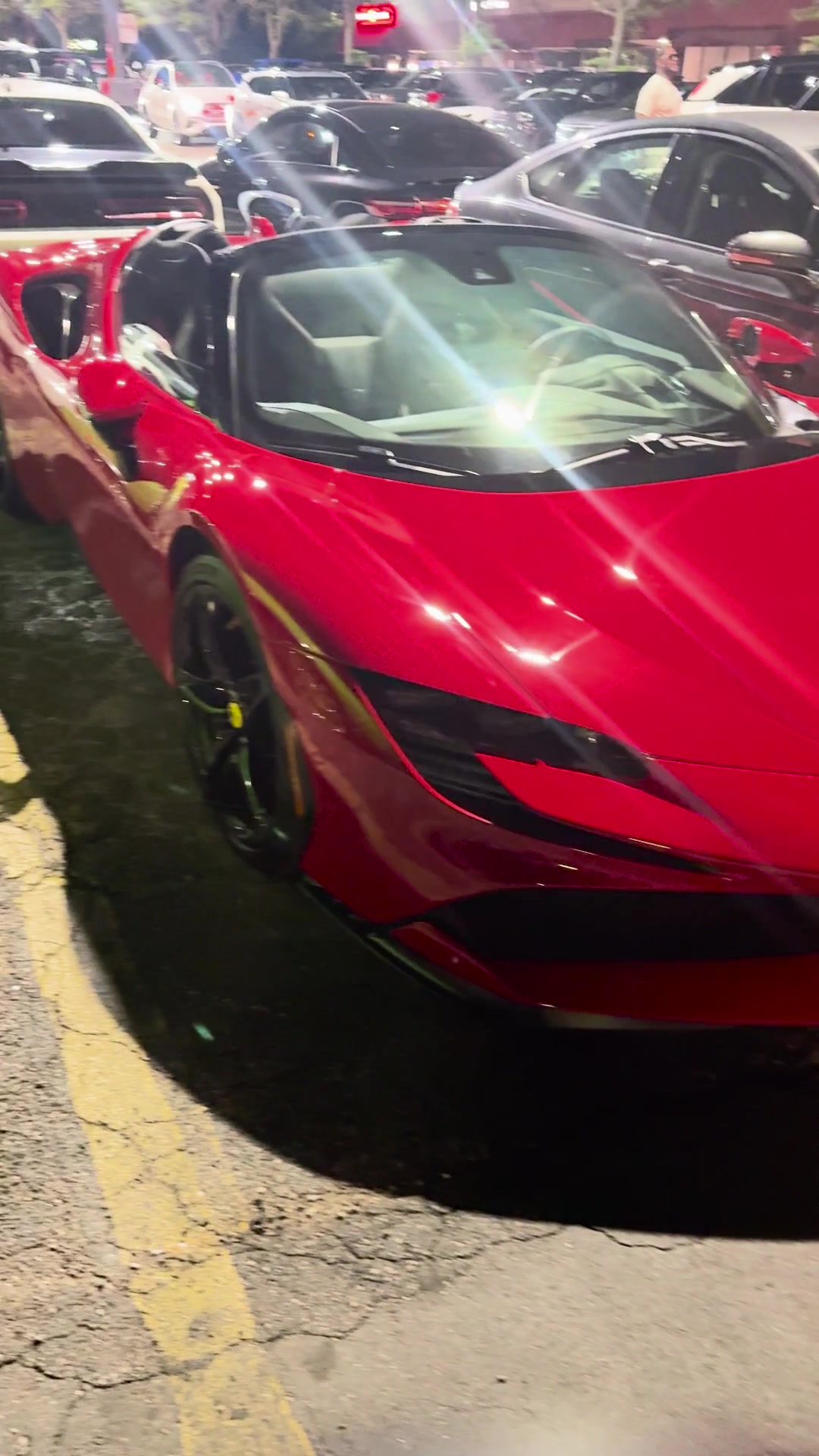 A red convertible sports car at an evening event
